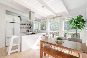 旧金山Charming Victorian Oasis with an Elegant and Spacious Haven的一间带木桌的厨房和一间带白色橱柜的厨房