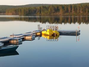 SevettijärviSevetin Baari & Guesthouse的坐在湖面上码头上的黄色小船