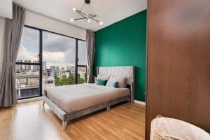 胡志明市DingD0ng Home FelizEnVista 5-star facilities的一间卧室设有一张大床和绿色的墙壁