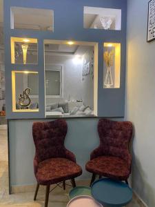 Ksar el KebirCozy apartment in Ksar el kebir的两个椅子,位于带镜子的等候室