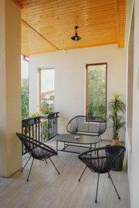 泰拉维Kera Rooms的阳台的天井配有三把椅子和一张桌子