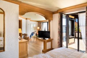特里尔佑蕾娜霍夫酒店的一间卧室设有一张床、一台电视和一个窗口。