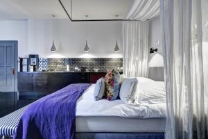 柏林高基公寓酒店的一间卧室配有一张大床和紫色毯子