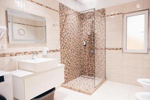 地拉那Mono Boutique Apartments的带淋浴、盥洗盆和卫生间的浴室