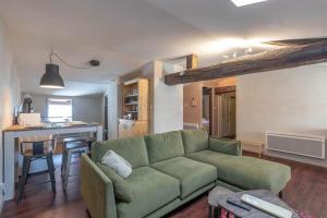 克卢尼Cabana & Le Chaleureux - Centre-Ville的一间带绿色沙发的客厅和一间厨房