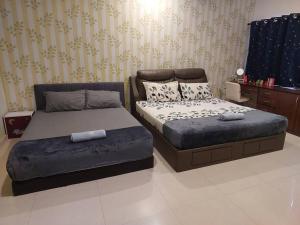 牛汝莪Home in Gelugor4R3B Dnaz Homestay@Sg. Dua的一间卧室配有两张床和一张搁脚凳