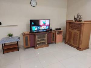 牛汝莪Home in Gelugor4R3B Dnaz Homestay@Sg. Dua的一间带电视和木制家具的客厅