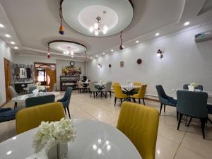 努库斯MASSAGET HOTEL的用餐室配有桌子和黄色椅子