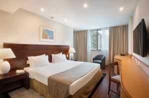 里约热内卢温莎广场科帕卡巴纳酒店的酒店客房配有一张床、一张书桌和一台电视。