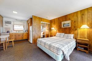 AltonKing Birch Lake Home, Unit 6的一间带木墙和一张床的卧室以及一间厨房
