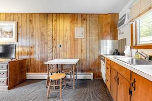 AltonKing Birch Lake Home, Unit 6的厨房设有木墙和桌椅