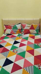 穆扎夫法尔普尔Shubham guest house的床上配有色彩缤纷的被子和枕头
