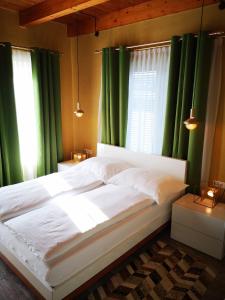 巴德瓦尔特斯多夫Aparthotel "Goldener Hahn Apartments"的一间卧室配有一张带绿色窗帘的大床
