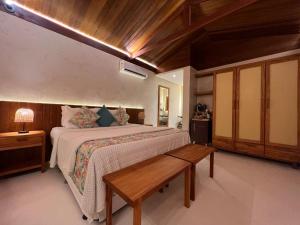 费尔南多 - 迪诺罗尼亚Pousada Naonda的一间卧室设有一张大床和木制天花板