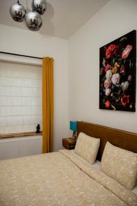 布鲁塞尔Beauty Suite的卧室配有一张床,墙上挂有绘画作品