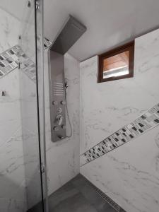 巴尼奥斯Casa y Flores的一间铺有白色大理石的淋浴浴室