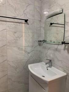 古多里bismillah hotel and restaurent的白色的浴室设有水槽和镜子