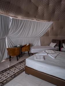 瓦迪拉姆SUN LUXURY CAMP &Tour的一间卧室配有两张床、一张桌子和一张桌子