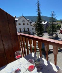 毕斯卡斯PLAZA centro的阳台上的桌子和两杯葡萄酒