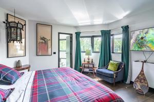 伊维特河畔吉夫Utopia home的一间卧室配有一张床、一把椅子和窗户。