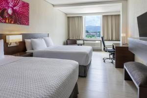 Tocumen机场皇冠酒店的酒店客房配有两张床和一张书桌