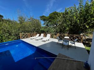 哈拉瓦科阿Villa unter Palmen的一个带椅子的庭院和一个游泳池