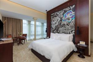 利马Country Club Lima Hotel – The Leading Hotels of the World的酒店客房设有一张大床和壁画