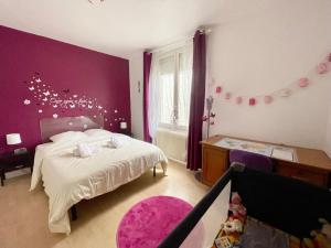 诺伊斯·勒·格兰德La Casa - Charmante maison entre Paris & Disney的一间卧室配有一张床和紫色的墙壁