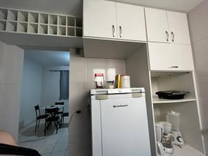 乌贝兰迪亚Apartamento inteiro próximo a Algar, Cargill, Aeroporto e UFU的厨房配有白色冰箱和桌子