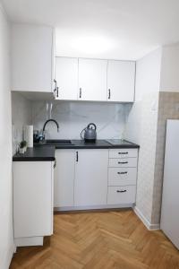 华沙ClickTheFlat Three Crosses Square Apart Rooms的白色的厨房配有白色橱柜和木地板