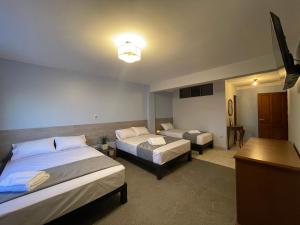 科恰班巴Izza Hotel的酒店客房设有两张床和一张桌子。