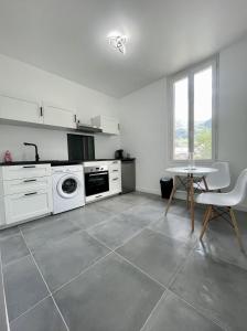 皮埃尔菲特－内斯塔拉Charmant Studio Pyrénéen的厨房配有白色家电和桌椅