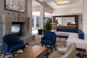 巴吞鲁日巴顿鲁日机场希尔顿花园酒店的客厅配有蓝色椅子和壁炉