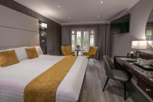 布里真德Best Western Premier Heronston Hotel & Spa的酒店客房设有一张大床和一张书桌。