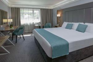 布里真德Best Western Premier Heronston Hotel & Spa的酒店客房设有一张大床和一张书桌。