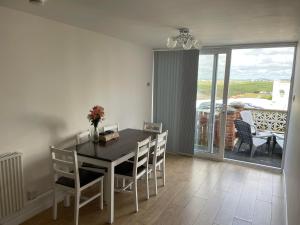纽基Newquay Fistral Beach View的一间带桌椅的用餐室和一个阳台