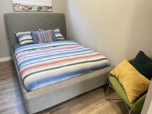 卡尔加里Cozy basement suite的一张带条纹毯子和椅子的床