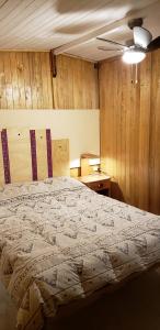 卡瓦纳科德Llahuar Lodge的一间卧室设有一张床和木墙