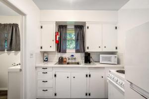 Ocean ParkCute as a Clam Cottage Room 5的白色的厨房配有白色的橱柜和微波炉