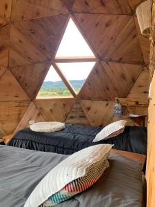 特来凡林Nomade Patagonia Glamping & Domos的客房设有两张床和窗户。