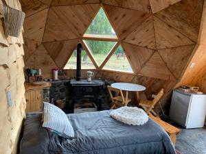 特来凡林Nomade Patagonia Glamping & Domos的帐篷内带一张床和炉灶的房间