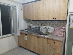 格克切达镇Avcı Pansiyon的厨房配有木制橱柜、水槽和窗户。