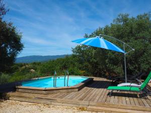 GramboisNice house with private pool in the Parc du Luberon, Grambois的一个带蓝伞、椅子、桌子和椅子的游泳池