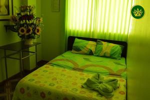 齐克拉约HOTEL REY DE ORO的绿色卧室配有床和鲜花桌