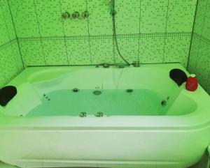 齐克拉约HOTEL REY DE ORO的绿色瓷砖浴室内的白色浴缸
