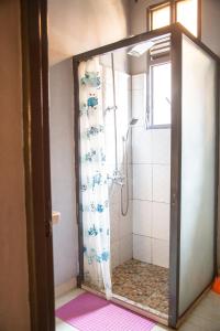 布琼布拉Ruhuka House的浴室里设有玻璃门淋浴