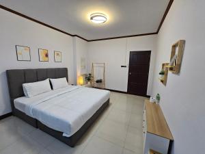 Ban Komo Sip PaetAnda Betong Homestay的一间卧室配有一张大床和一张木桌