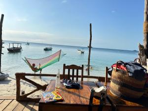 基林多尼Juani beach bungalows的吊床和桌子,享有海景