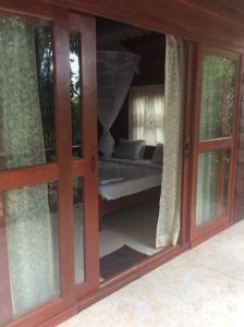瓜隆岛Sambath Sakseth Bungalow的滑动玻璃门,在房间内配有床