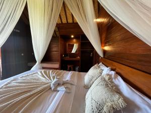 蓝梦岛Sunset Hill Lembongan的一间卧室配有一张带白色床单和窗帘的床